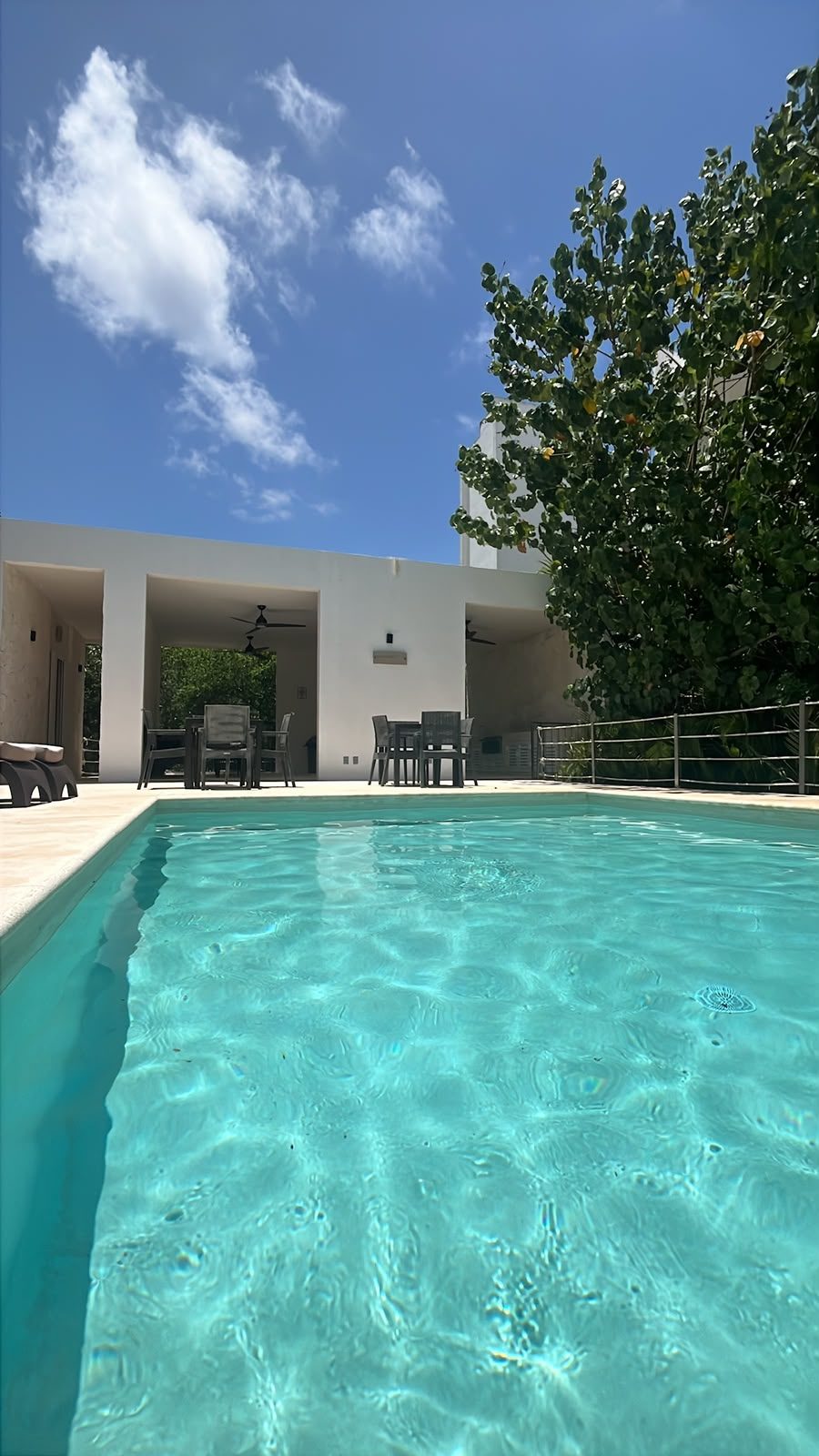 Alberca del hospedaje en el centro de Tulum con agua turquesa y cielo despejado.