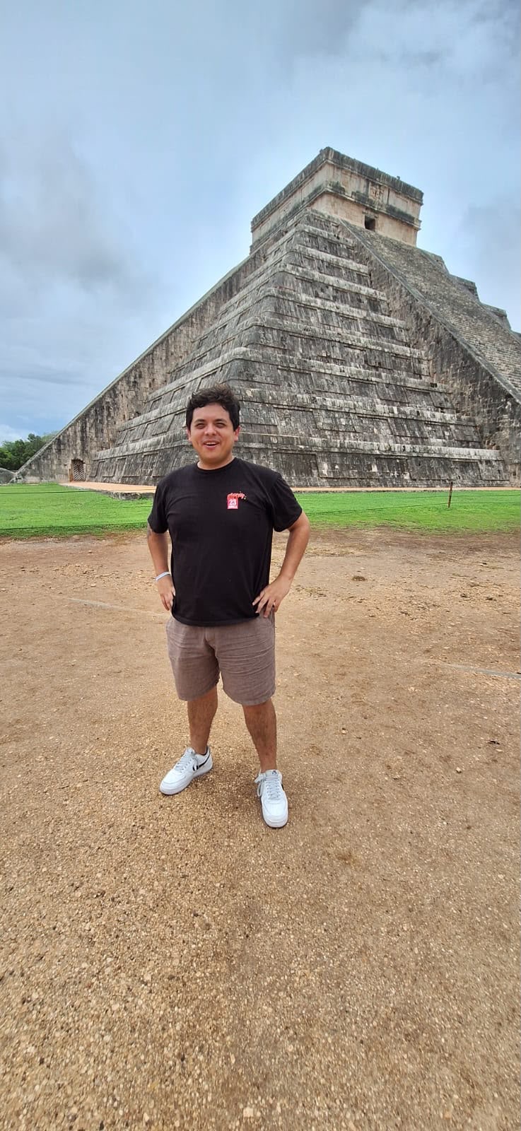 Turista de pie frente a la pirámide de Kukulkán en Chichén Itzá, Yucatán