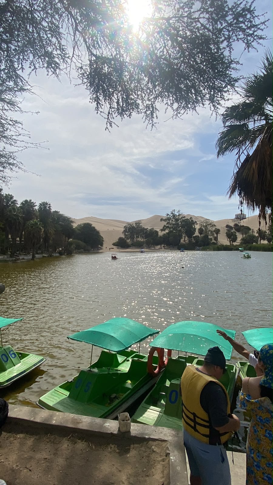 Atardecer sobre las dunas de arena de Huacachina con vehículos buggy a lo lejos