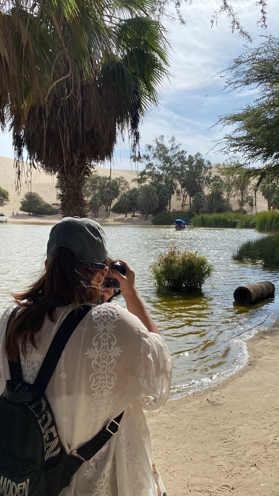 Laguna de Huacachina rodeada de palmeras y dunas de arena en Ica, Perú