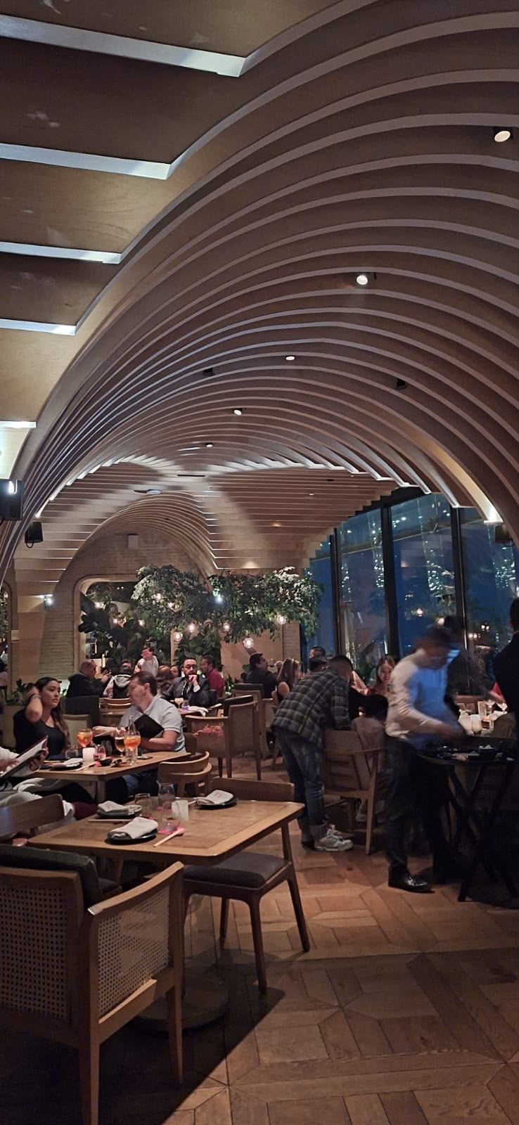 Salón interior de Ling Ling con techo de arcos de madera y mesas puestas, CDMX