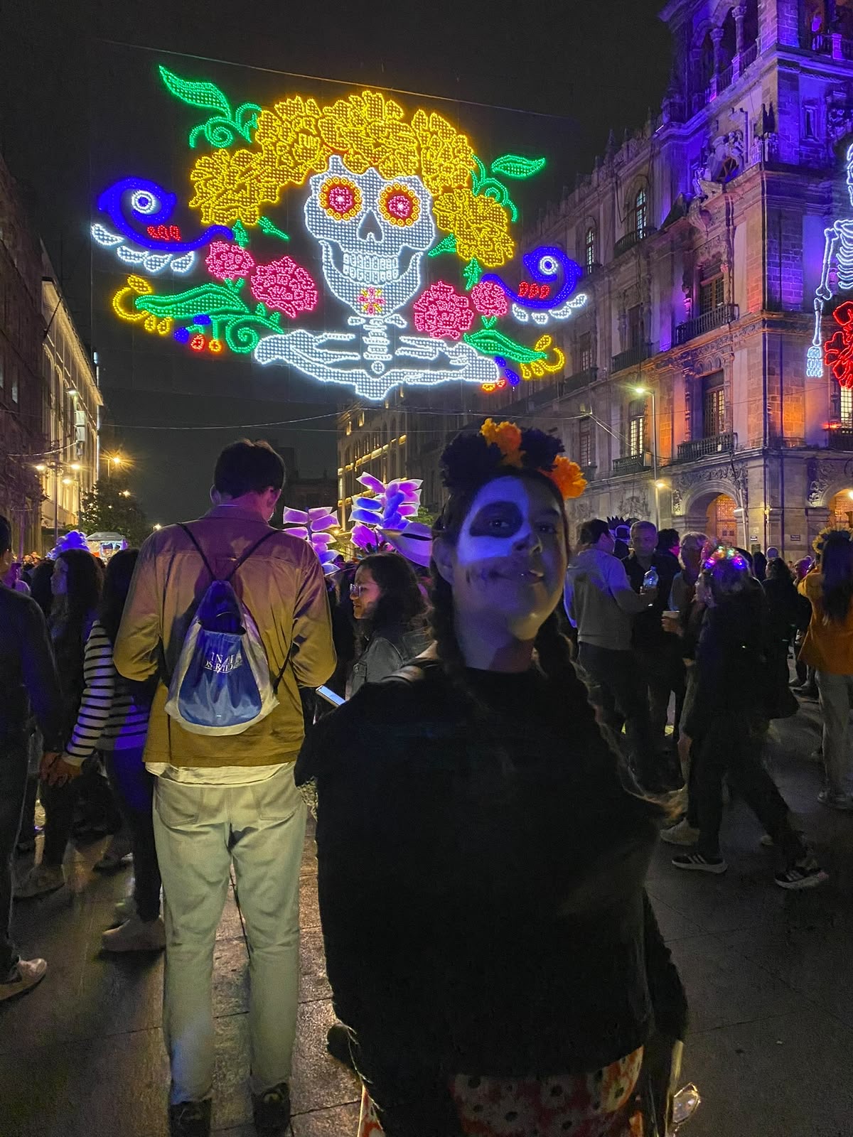 Pareja maquillada de catrina caminando entre la multitud del Centro Histórico en Día de Muertos
