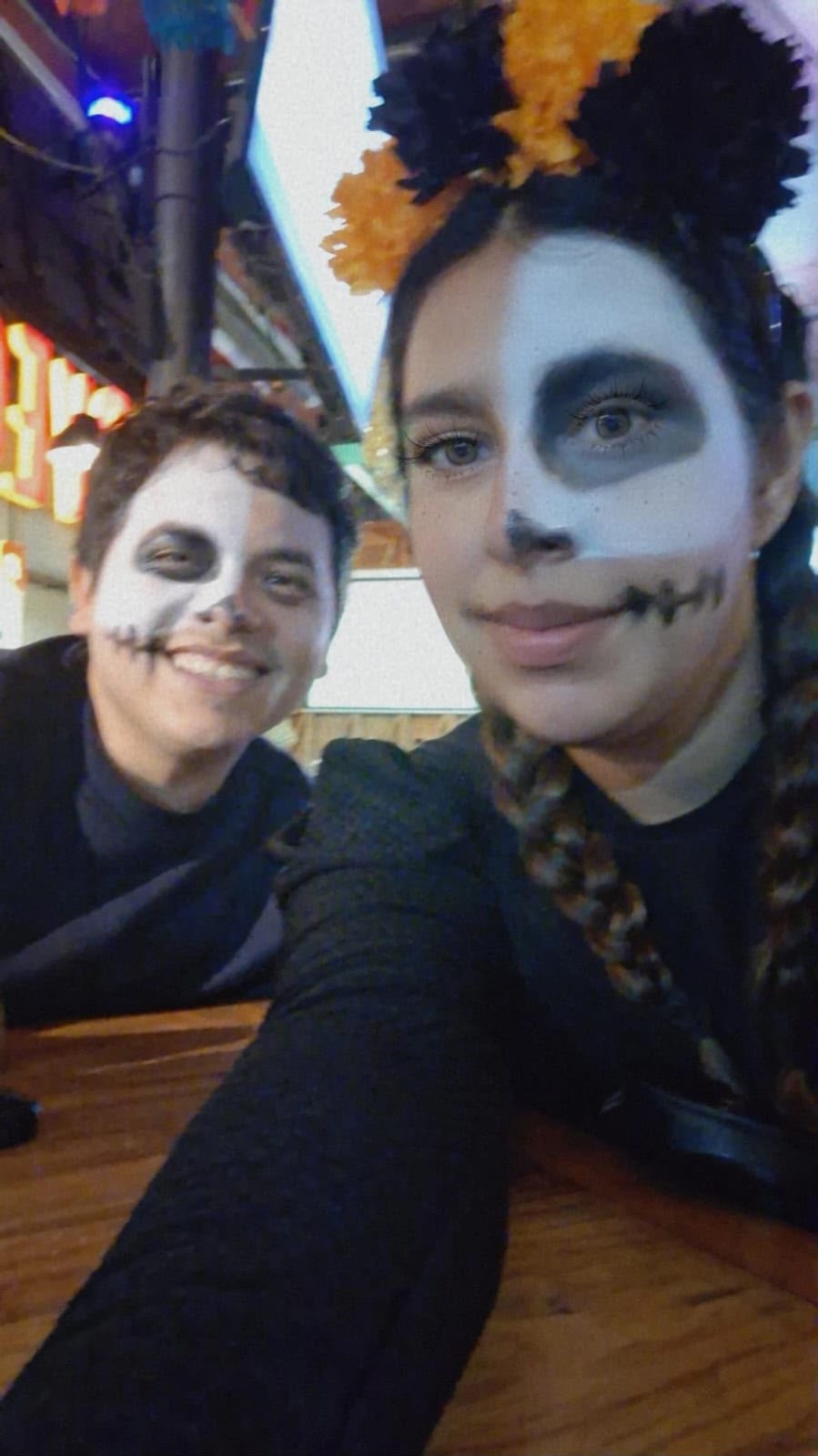 Pareja con maquillaje de catrina y catrín a medio terminar antes de ir al Zócalo