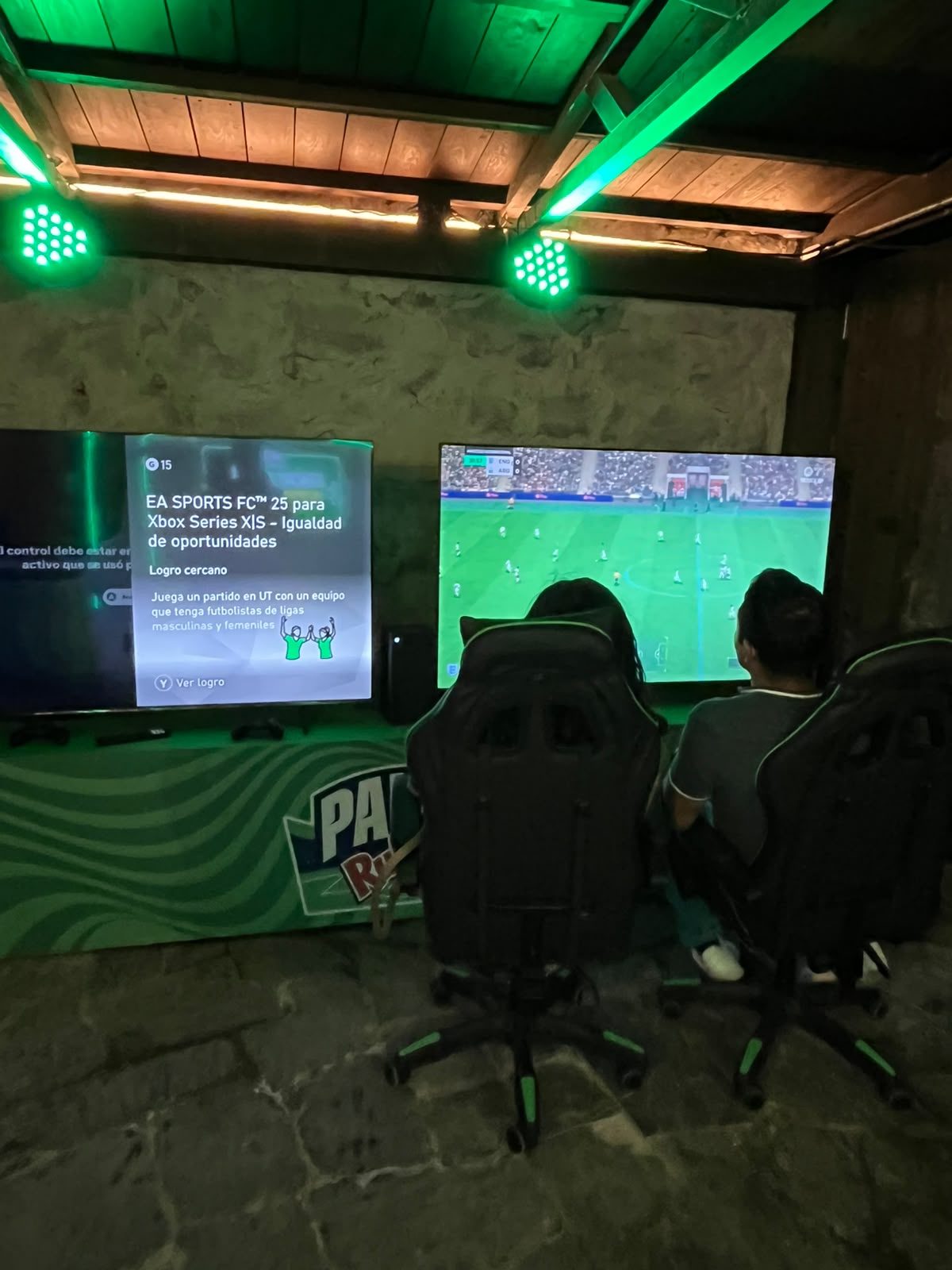 Dos asistentes juegan EA Sports FC 25 en Xbox Series X en una estación gamer del Palco Ruffles.
