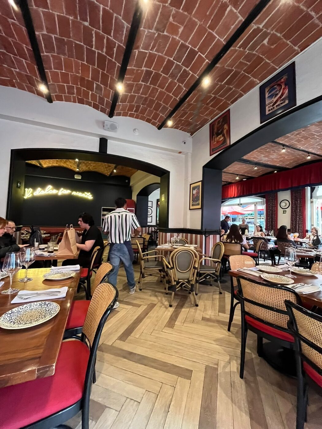 Salón de Marcello con el neón «Il dolce far niente», bóvedas de ladrillo y carteles italianos vintage