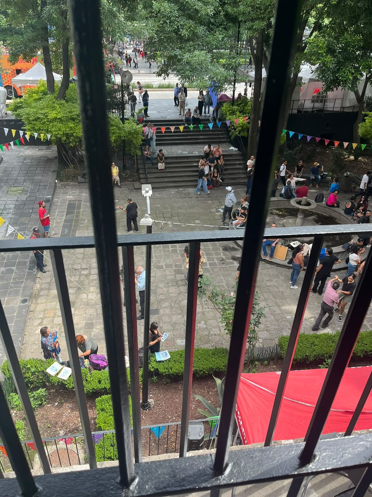 Patio del Museo Nacional de la Estampa lleno de gente con papel picado y la carpa roja durante el evento Posada Cumbiero