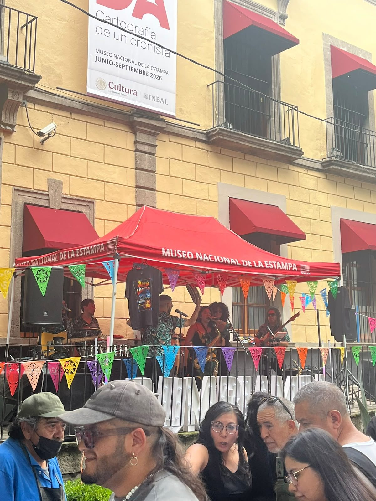 Fachada del Museo Nacional de la Estampa con la lona de la exposición Posada. Cartografía de un cronista y la banda Rumbiamba tocando en el patio
