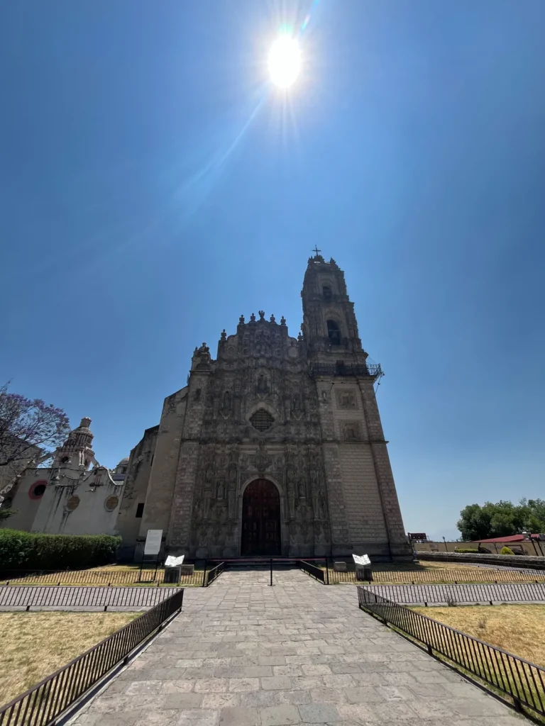 Atrio empedrado y fachada barroca del templo de San Francisco Javier en Tepotzotlán con el sol de frente