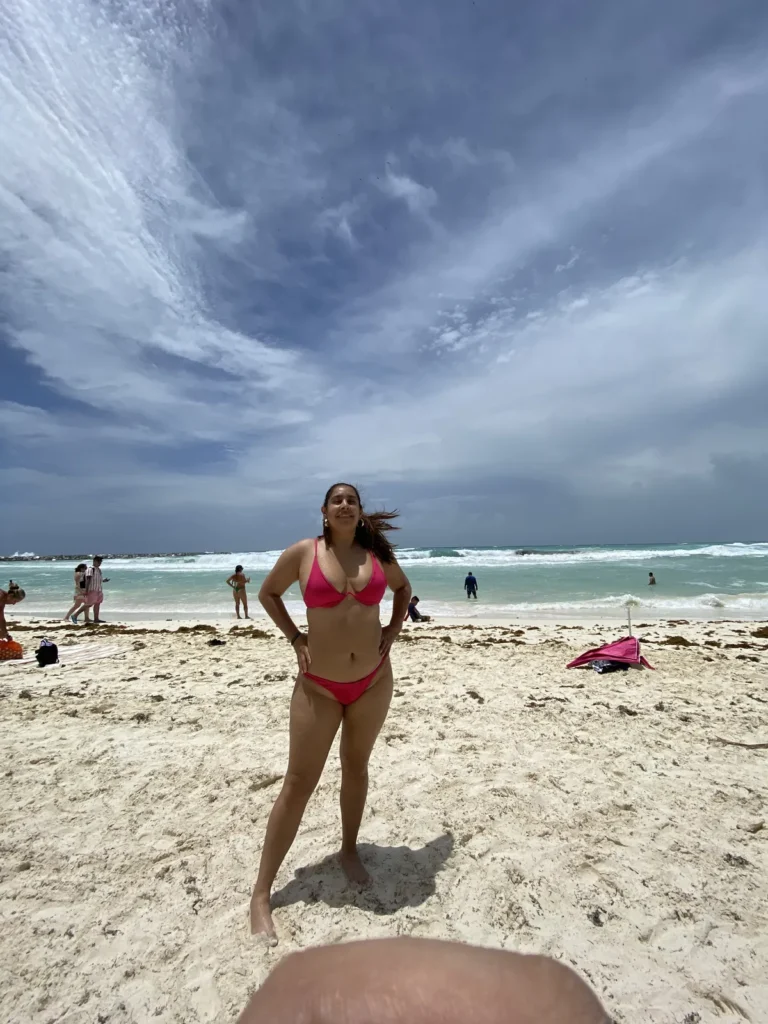 Playa de Punta Cancún con arena blanca, mar verde turquesa y cielo con nubes