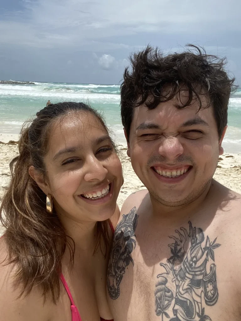 Pareja sonriendo en una selfie en la playa de Punta Cancún