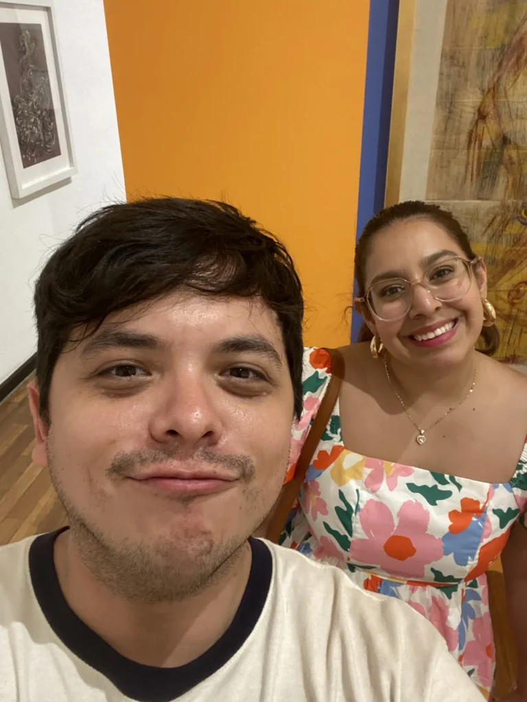 Pareja sonriendo en una sala de muros naranja del Museo Cabañas, mayo de 2024