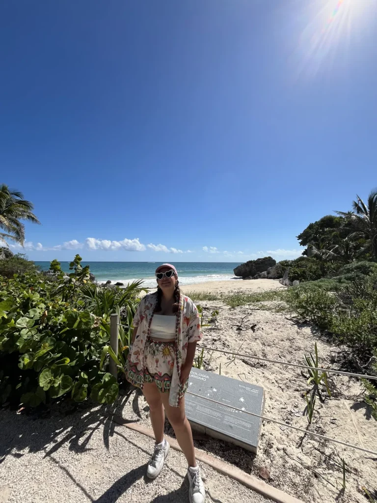 Acceso de arena entre vegetación hacia la playa dentro de la zona arqueológica de Tulum