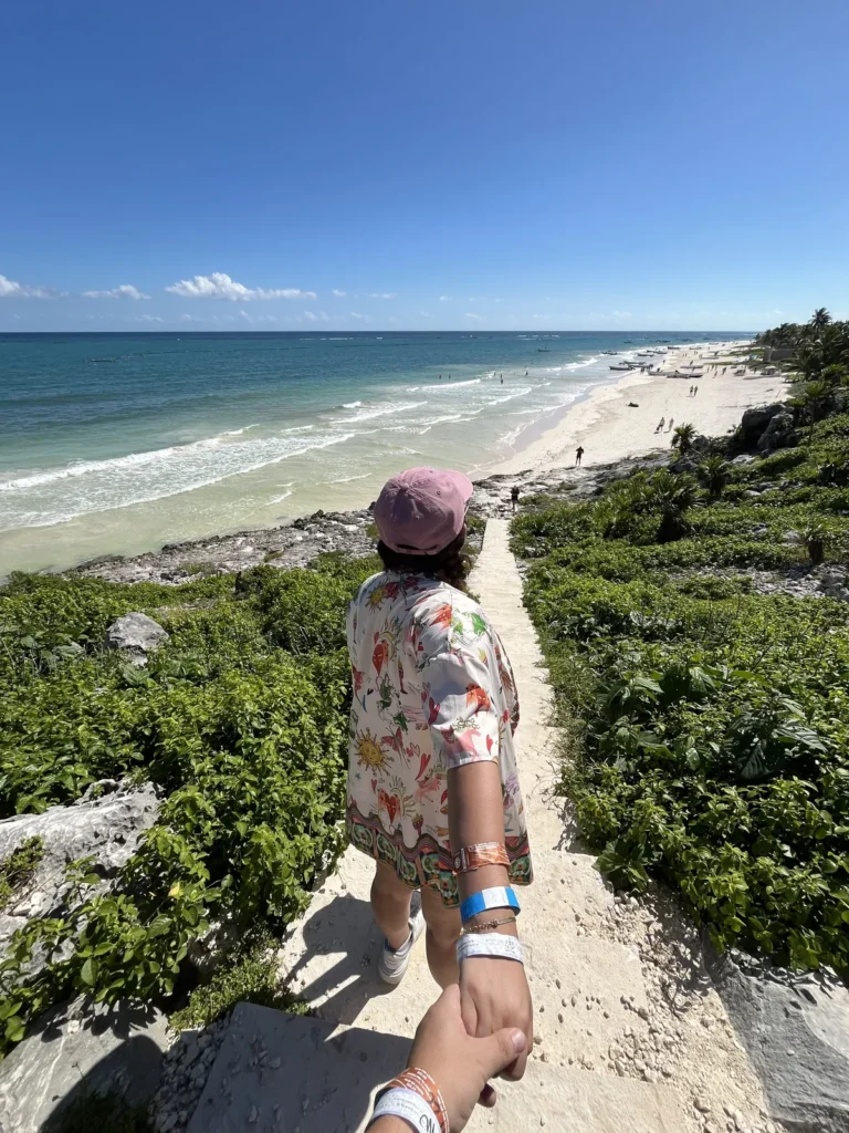 Vista desde arriba de un sendero que baja entre vegetación hacia la playa de Tulum