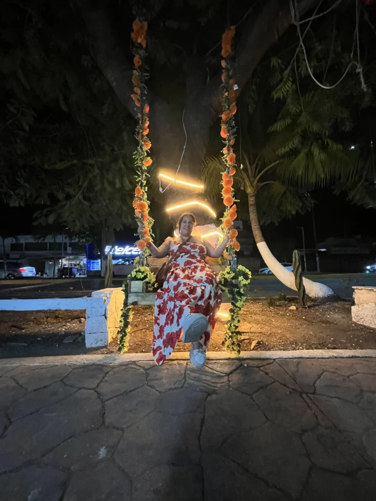 Columpio iluminado con luces y flores en el pueblo de Tulum de noche