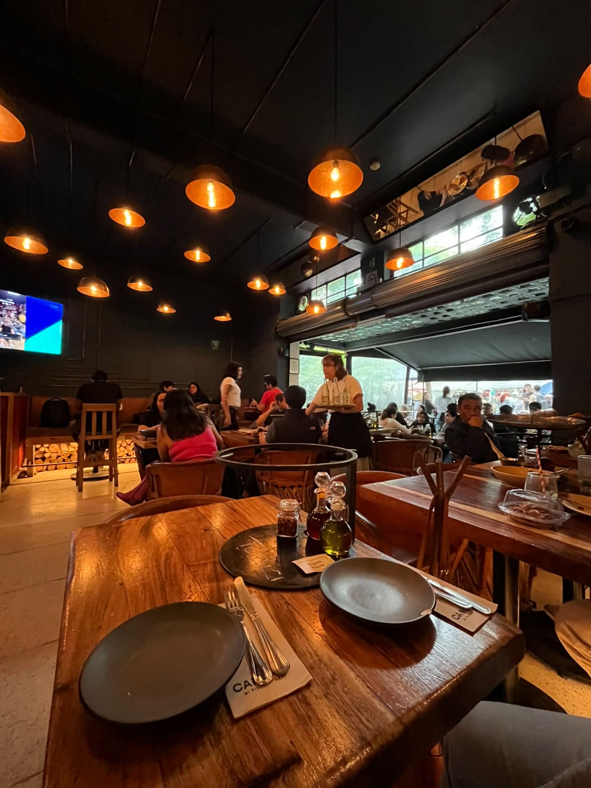 Interior de Cancino con techos altos, luz cálida y mesas de madera en el Centro Histórico