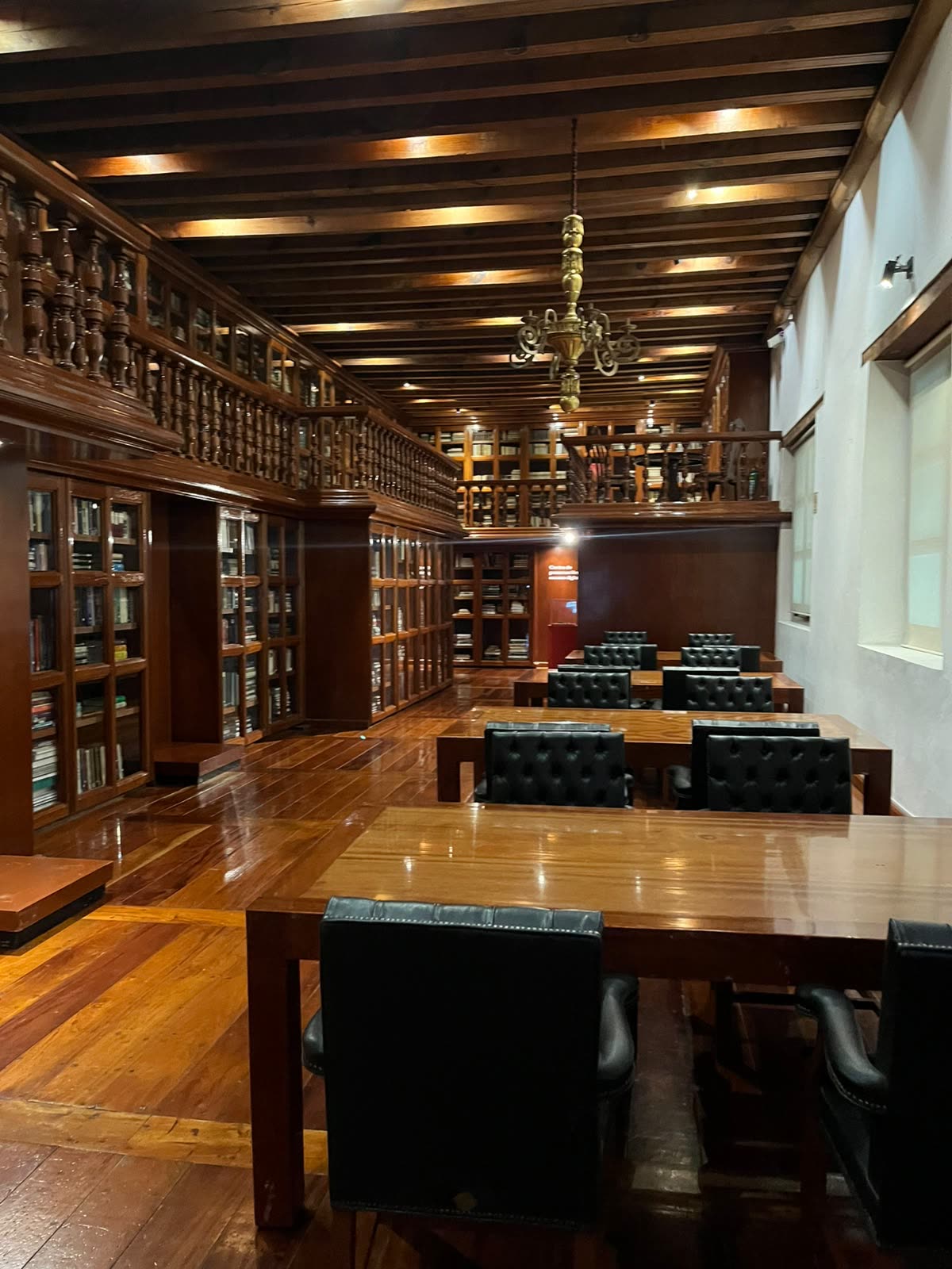 Sala de lectura de madera con candiles en la biblioteca del Museo Franz Mayer